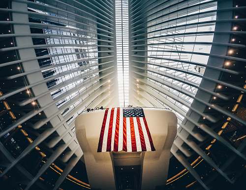 united states bottom photography of grey metal building and USA flag new york